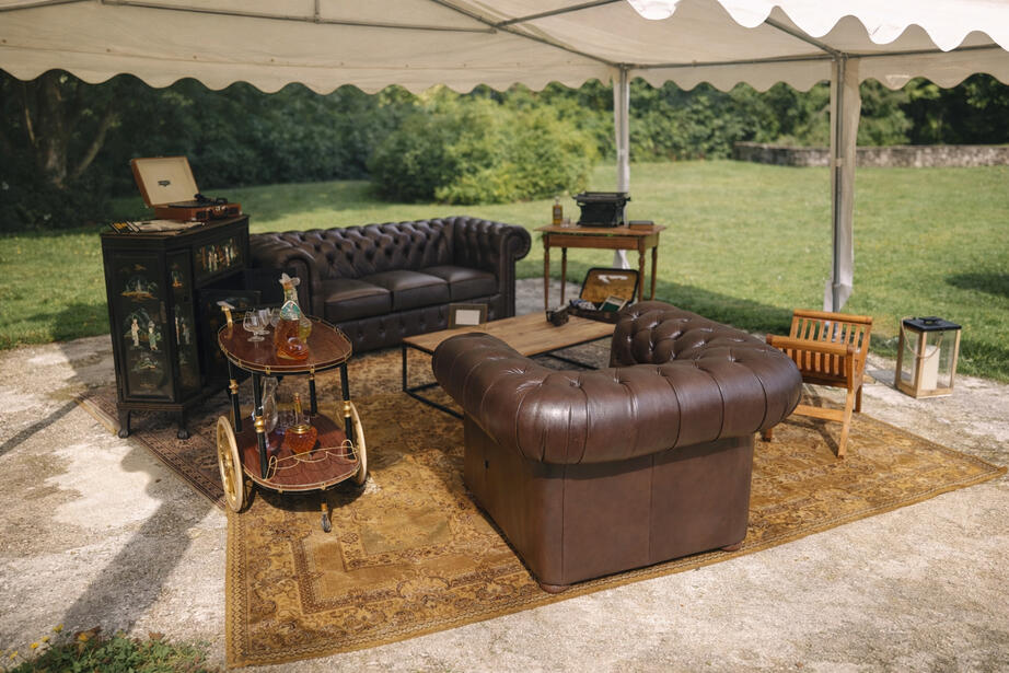 Coin Chesterfield : à la demande du client, j’ai mixé deux meubles laociens en hommage à la mariée avec un canapé Chesterfield, pour un rendu masculin et cosy, type salon anglais.